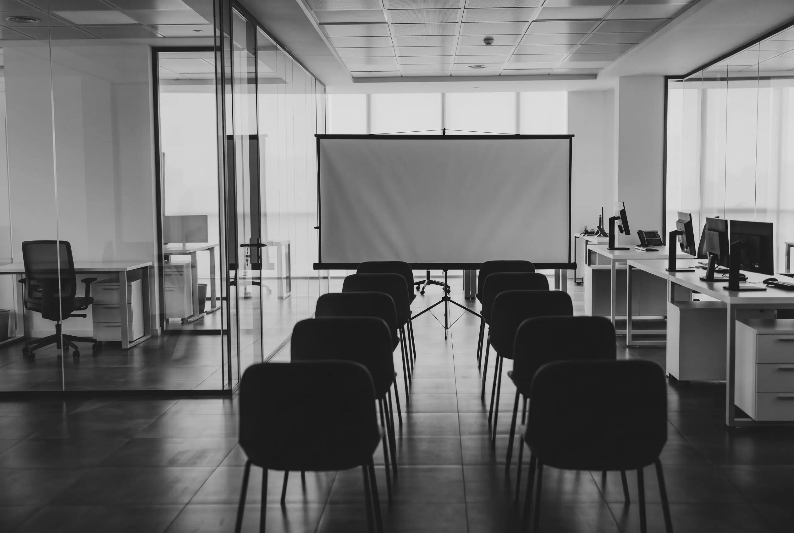 Una moderna sala riunioni con sedie e schermo per proiezioni, sede della BEHOME Academy dedicata all'apprendimento continuo e alla crescita professionale dei collaboratori.