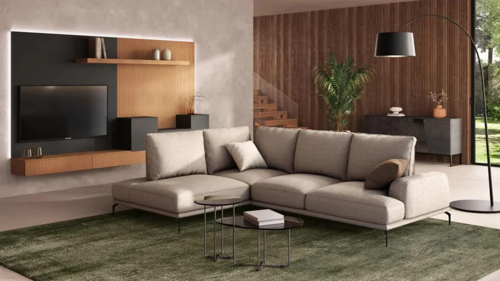 Divano angolare Eraclea Ang di BEHOME in tessuto beige con piedini neri su tappeto verde.