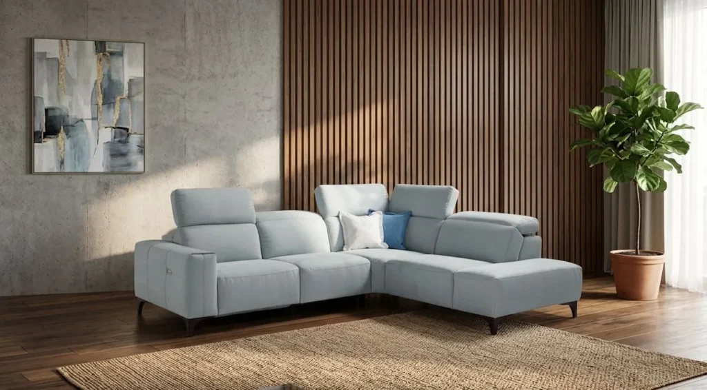 Vista frontale del divano angolare Marea di BEHOME azzurro in un elegante soggiorno.