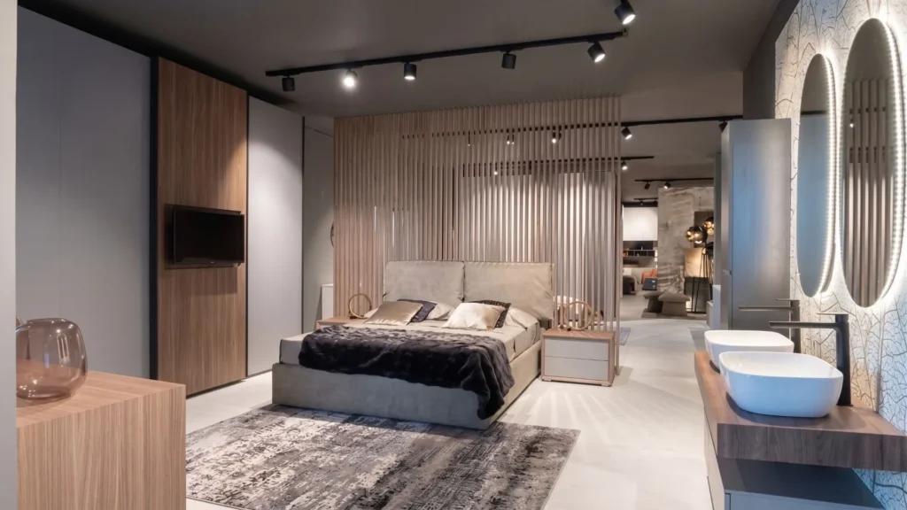 Ambientazione zona notte con letto matrimoniale imbottito e sezione arredo bagno all'interno del nuovo punto vendita BEHOME a Grosseto.